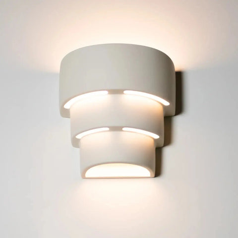 The Santa Cruz Sconce by A19 Artisan Lighting is a modern, handcrafted wall light made in California, featuring three curved layers and energy-efficient LED smart bulbs for soft up-and-down lighting with a warm glow.
