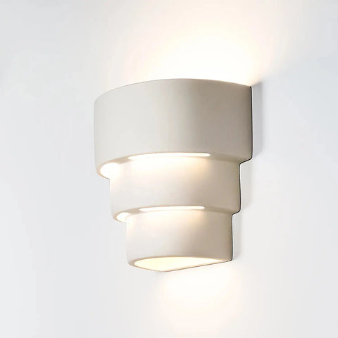 The Santa Cruz Sconce by A19 Artisan Lighting is a modern, handcrafted wall fixture made in California. Its tiered white design emits soft LED light up and down, ideal for contemporary, minimalist interiors.