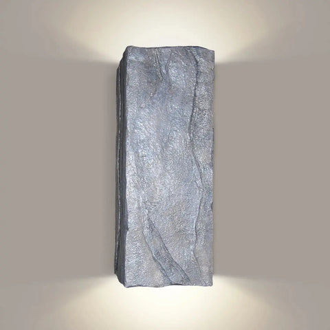 The Modern USA-Made Wall Lighting – Stone Sconce by A19 Artisan Lighting is a rectangular, textured fixture handcrafted in California that softly illuminates both up and down against a neutral background.