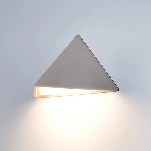 The Modern USA-Made Sumatra Downlight Sconce by A19 Artisan Lighting, handcrafted in California, offers a sleek look and energy-efficient LED, softly illuminating white walls and surfaces with warm light.