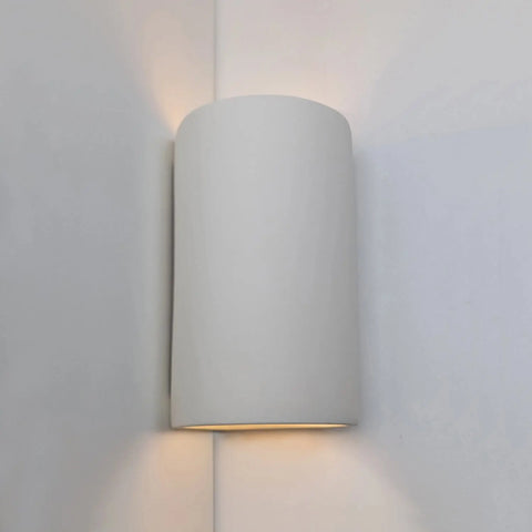 The Tenos Corner Sconce by A19 Artisan Lighting is a handcrafted, modern USA-made white cylinder sconce that softly casts light up and down on a light wall, bringing a subtle contemporary touch to your space.