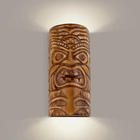 A cylindrical Tiki sconce with an up-and-down light pattern, featuring a nature-inspired design with a face motif.