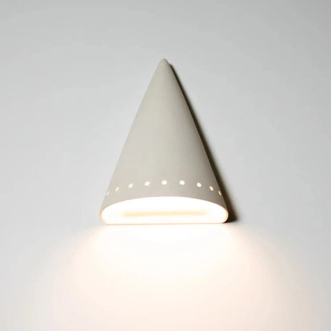 The Modern USA-Made Zealandia Downlight Sconce by A19 Artisan Lighting is a handcrafted, white ceramic wall lamp with a cone shape and small circular holes that softly illuminates your wall with a subtle glow. Made in California.