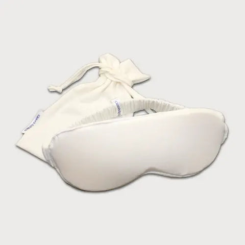 The Goodnighties Sleep Mask With Pouch features a soft, handcrafted sleep mask with an elastic band, displayed in front of its matching white drawstring pouch on a light background.