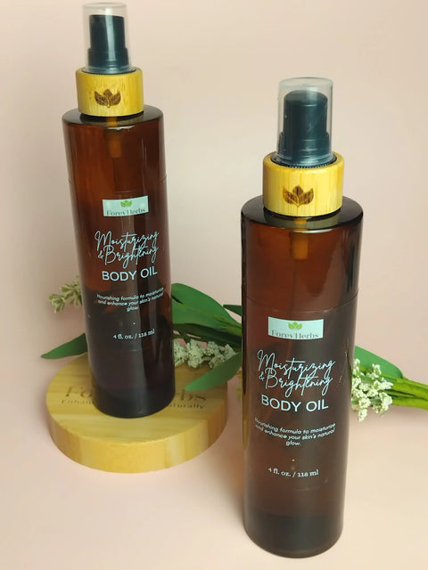 Two amber Forev'Herbs Moisturizing & Brightening Body Oil bottles with bamboo-style caps stand upright—one on a wooden platform, surrounded by green leaves and white flowers, infused with Natural Fruit AHAs.