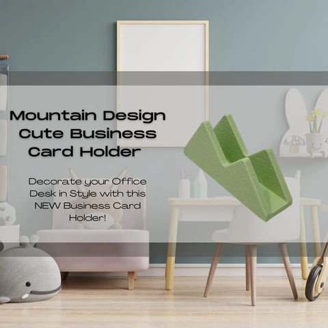 A modern office features the Mountain Silhouette Design Business Card Holder by Chatelet Manufacturing, with a text overlay inviting stylish desk decor. Plush toys and art supplies complete this charming organizer scene.