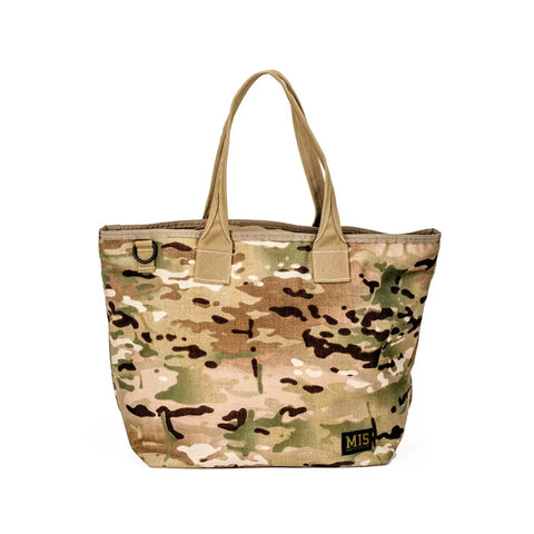 The MIS Tote Bag - Multi Cam is a camouflage-patterned Cordura Nylon bag with two handles, a heavy-duty zipper, and an M15 patch in the bottom right corner, shown against a white background.