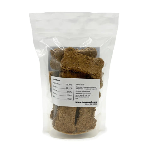 A clear, resealable plastic bag of large, bone-shaped Drunken Moose treats by Brewscuits stands upright on a white background. The front label displays nutritional facts and ingredients like moose antler dust for these natural dog treats.