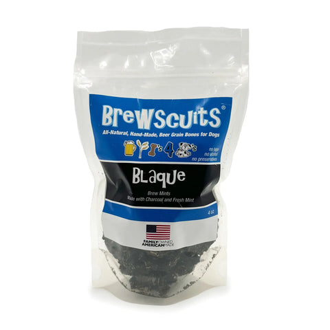 A clear resealable bag labeled Brewscuits Blaque holds natural dog treats with activated charcoal and fresh mint for fresh breath. The packaging features blue and white text, icons, and an American flag.