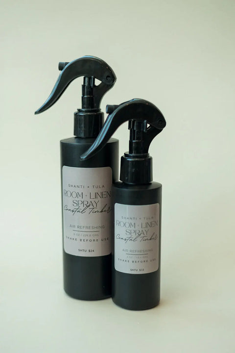 Two black Shanti + Tula Natural Room & Linen Spray – Odor Neutralizer & Air Refresher bottles, the larger behind the smaller, stand side by side on a light background. Made in the USA.