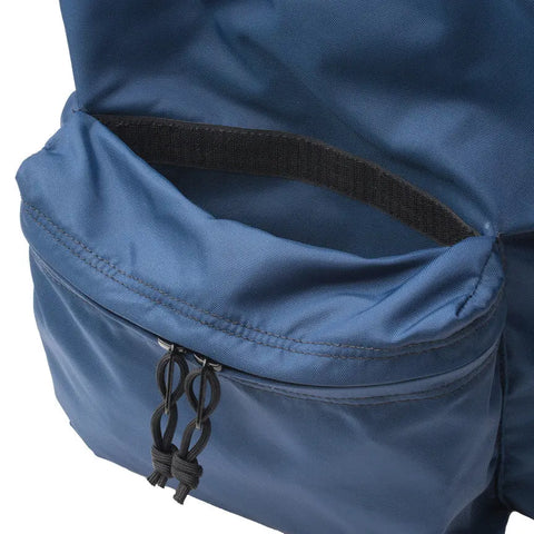 Close-up of MIS Daypack - Navy’s front pocket, partially unzipped to show a black mesh organizer inside. The pocket has two black zipper pulls with knotted cord loops.