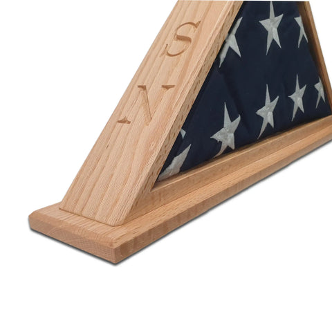 A close-up of the Legacies of America Woodworking Companys Navy Veteran USN Oak Burial Flag Display Case (5 x 9.5), holding a folded American flag with engraved letters on the oak wood. Made in the USA.
