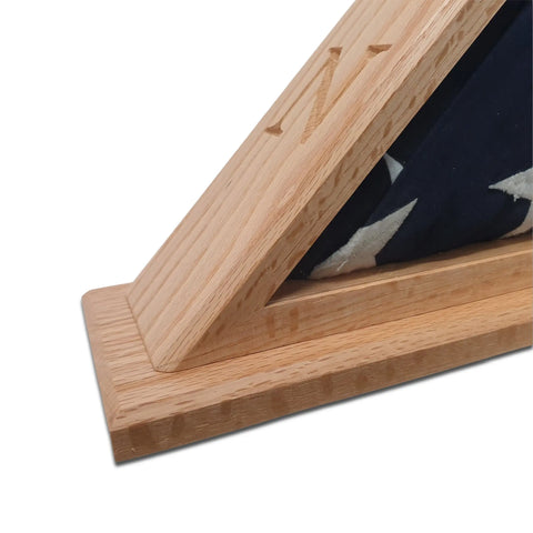 A close-up of the Legacies of America Woodworking Company’s Navy Veteran USN - Oak Burial Flag Display Case (5 X 9.5), holding a folded American flag with a carved N, made in the USA to honor Navy service.