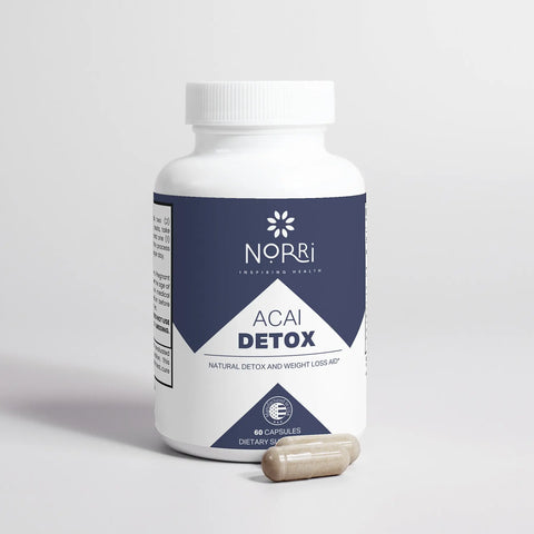 A white bottle labeled Norri Nutrition Acai Detox sits on a white surface with two beige capsules beside it. This detox supplement contains 60 capsules and supports natural detox and weight loss.