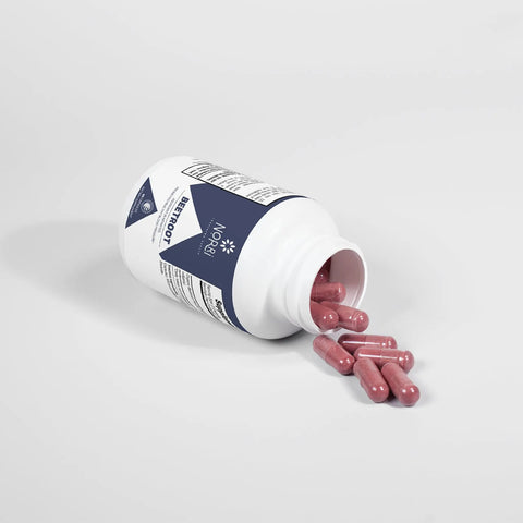 A white Norri Nutrition Beetroot bottle lies on its side on a white surface, with red capsules spilling from the open lid—ideal for supporting cardiovascular wellness.