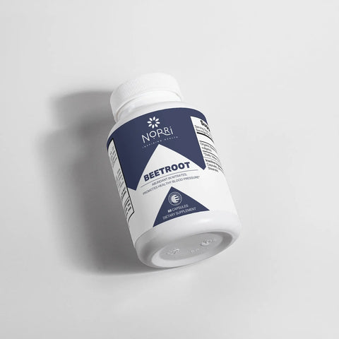 A white bottle of Norri Nutrition Beetroot capsules with a blue and white label lies on its side against a light background. The label emphasizes beetroot’s cardiovascular wellness benefits.