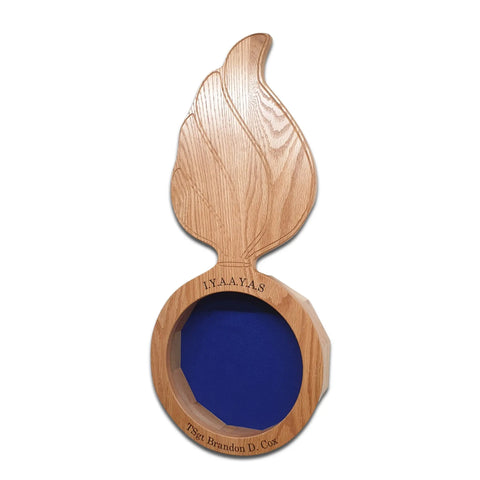 The Oak Ammo Pisspot Shadow Box by Legacies of America Woodworking Company features a flame-shaped oak display with a blue center, circular base engraved I.N.A.A.Y.A.S. 75th Brandon D. Cox, all set against a white background.