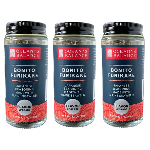 Three jars of Oceans Balance Bonito Furikake are shown side by side, each with a red and navy label featuring white text and a black screw-top lid.