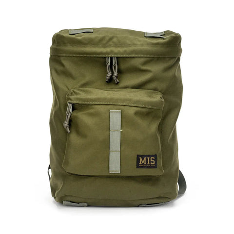 The MIS Backpack - Olive Drab is made in the USA from Cordura Nylon, featuring a front zip pocket, light gray zipper pulls, a black logo patch, adjustable straps, and a padded laptop holder in a simple utilitarian design.