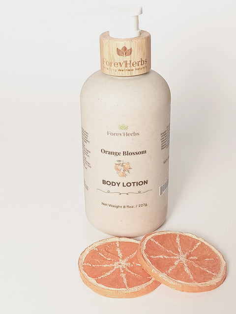 A bottle of Forev'Herbs Orange Blossom Lotion with a pump top rests on a white surface beside two dried orange slices, showcasing this natural lotion infused with sweet orange essential oil.