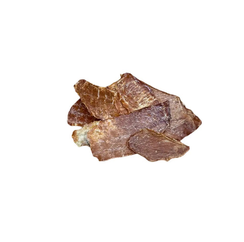 Several pieces of Dogtown Bakery Chunky Ginger Chicken, dried brown organic dog treats, are stacked on a white background.