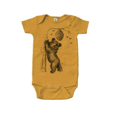 The Spiritex Honey Bear Graphic Bodysuit is a mustard yellow, organic cotton baby bodysuit with a smiling bear reaching for a beehive—gentle on sensitive skin.