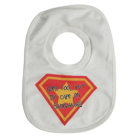 The Spiritex Pullover Bib | Backwards Cape features a white design with a red and yellow superhero emblem and Some fool put my cape on backwards!! playfully printed on the front.