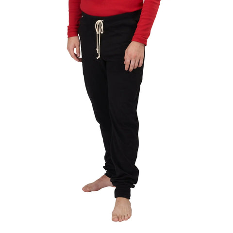 A person models Spiritex | Sustainable Apparel Drawstring Jogger Pants in black, barefoot against a white background. The pants have a drawstring waistband. Photo is cropped at the shoulders; head is not visible.