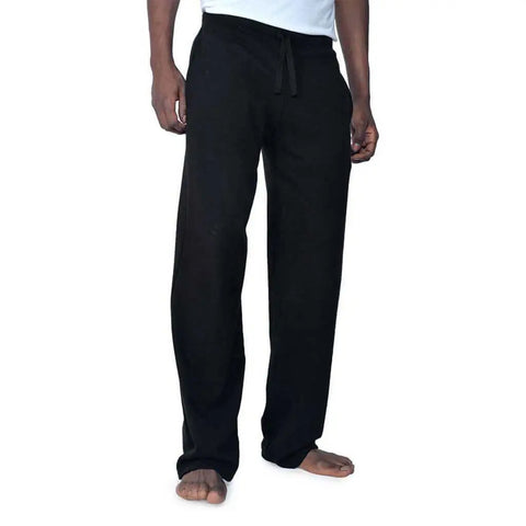 A person stands barefoot against a plain white background, wearing Spiritex | Sustainable Apparels black unisex Drawstring Lounge Pant and a white shirt.
