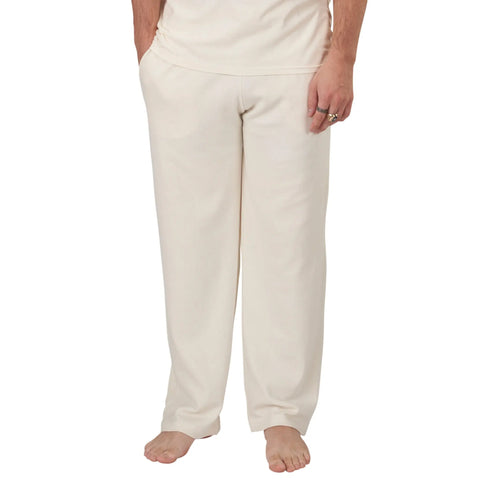 A person stands barefoot, wearing off-white Spiritex | Sustainable Apparel Drawstring Lounge Pant. The photo is cropped to show only the lower torso and legs.