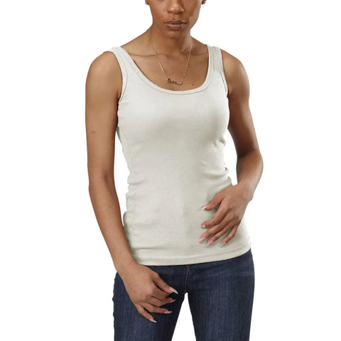 A person wears the Spiritex | Sustainable Apparel Classic Tank, a light beige sleeveless top made from 100% organic cotton, paired with blue jeans. They stand against a white background, one hand on their hip and the other by their side.