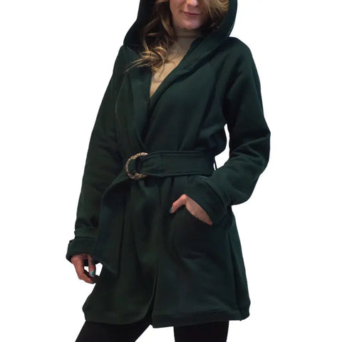 A woman wearing the Spiritex Fleece Wrap Jacket with a coconut shell belt and button closure stands with one hand in her pocket against a white background.
