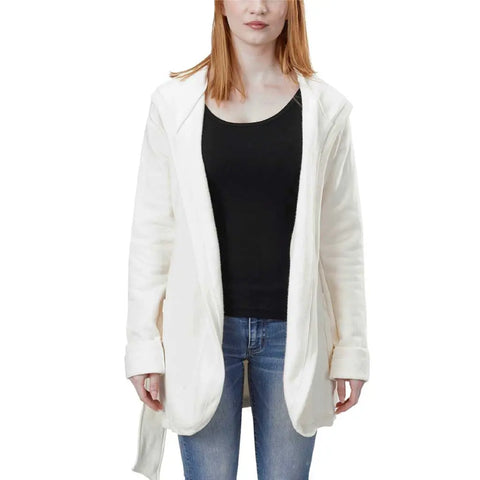 A woman with straight, shoulder-length red hair wears the Spiritex Fleece Wrap Jacket, a white open-front hooded cardigan made from organic cotton fleece, over a black top and blue jeans while standing against a white background.