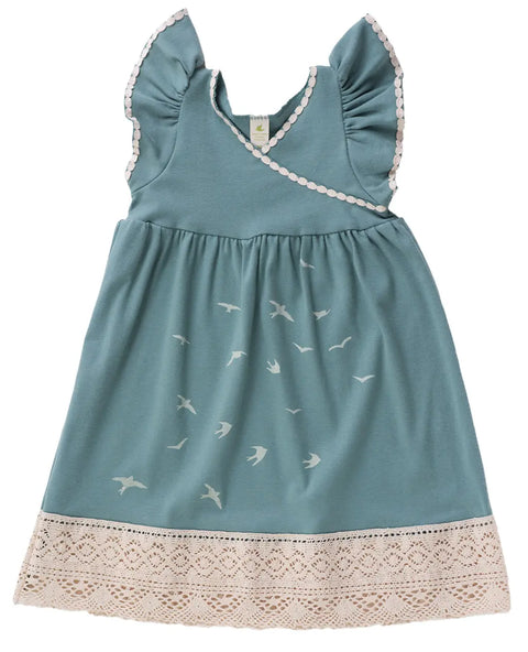 The Girls Bird Flock Dress by Spiritex | Sustainable Apparel is an organic cotton light blue dress with white trim, lace hem, bird silhouettes on the skirt, and ruffled shoulders.