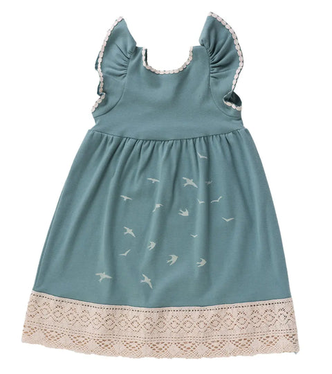 The Girls Bird Flock Dress by Spiritex | Sustainable Apparel is a sleeveless teal organic cotton dress featuring ruffled shoulders, white trim, a bird print skirt, and a wide cream lace hem.
