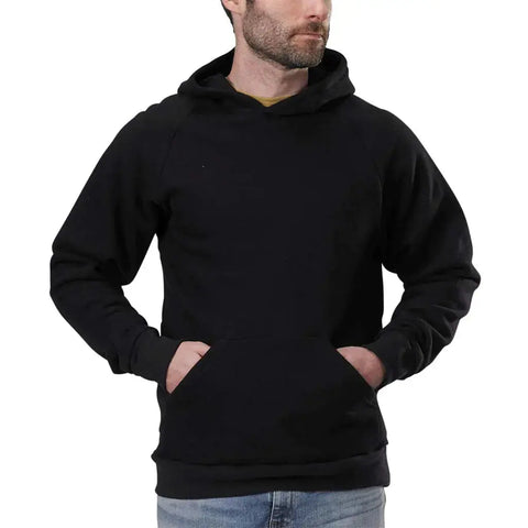 A man wears the Spiritex | Sustainable Apparel Heavyweight Fleece Hoodie in plain black, featuring a lined hood and front pocket, with light blue jeans. He stands slightly to the side with hands in the pocket against a white background.