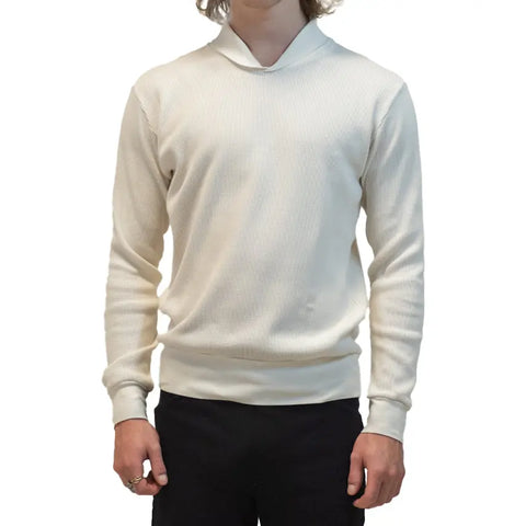 A person wears the cream Lexington Thermal Top from Spiritex | Sustainable Apparel with black pants, standing with arms relaxed at their sides against a plain white background.