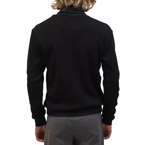 A person with shoulder-length blond hair is shown from the back, wearing the eco-friendly Lexington Thermal Top by Spiritex | Sustainable Apparel in black and gray pants against a plain white background.