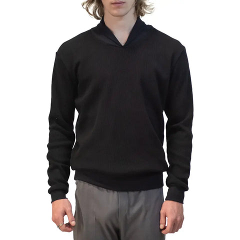 A person wears a black Lexington Thermal Top by Spiritex | Sustainable Apparel with gray pants, standing facing forward against a white background. The persons head is partially out of frame.