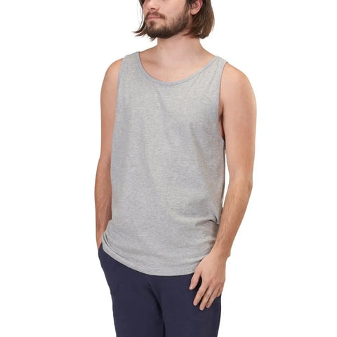 A person with shoulder-length hair and a beard wears the Spiritex | Sustainable Apparel Jersey Tank in light gray, made from 100% organic cotton, paired with dark pants, standing against a plain white background.