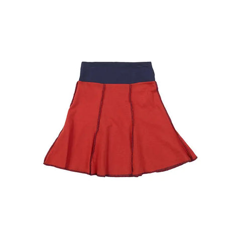 The Short Seamed Flare Skirt by Spiritex | Sustainable Apparel is a red A-line children’s skirt made from 100% organic cotton, featuring black stitching and a wide navy blue waistband. Grown & sewn in the USA. Laid flat on a white background.