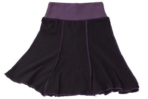 The Short Seamed Flare Skirt by Spiritex | Sustainable Apparel is a black flare skirt made in the USA from 100% organic cotton, featuring a wide dark purple waistband and purple seam stitching.