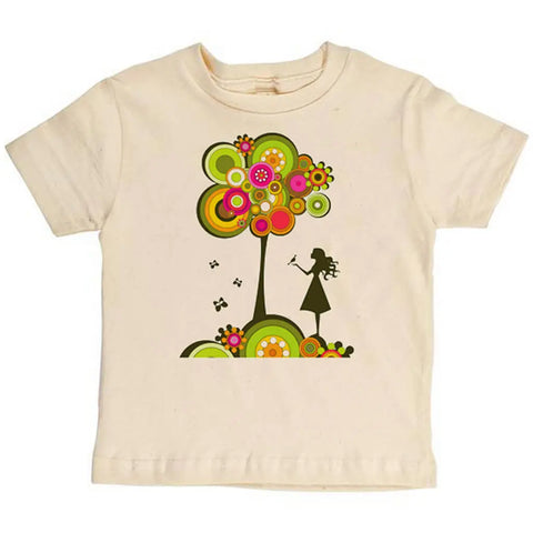 The Spiritex Girl With Tree Graphic Tee is a beige youth t-shirt featuring a playful graphic of a girl with a trumpet near an abstract, colorful tree. Made from soft organic cotton for kids who love unique, sustainable style.