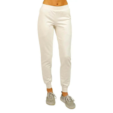 A person wearing white Lightweight Jogger Pants by Spiritex | Sustainable Apparel and gray sneakers, shown from the waist down against a plain white background.
