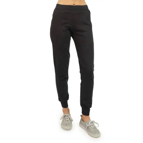 A person wearing black Lightweight Jogger Pants from Spiritex | Sustainable Apparel and gray sneakers stands against a white background. The image, cropped at the waist, highlights only the lower torso and legs.