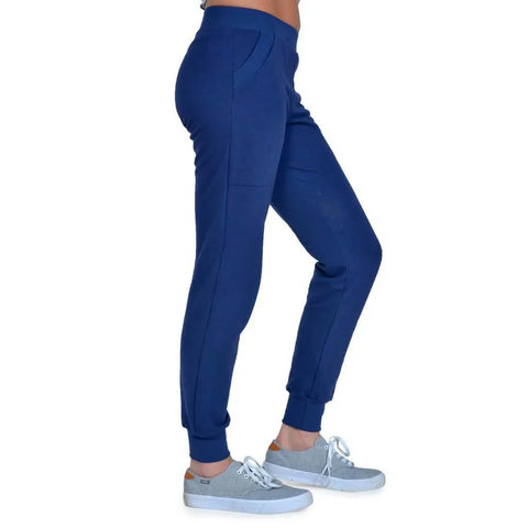 Person shown from the waist down in Lightweight Jogger Pants by Spiritex | Sustainable Apparel, blue organic cotton, paired with light gray sneakers, photographed from the side against a white background.