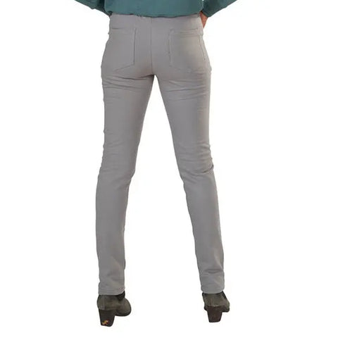 A person faces away from the camera, wearing Spiritex | Sustainable Apparels Lightweight Saratoga Pants in light gray with a skinny fit, paired with heeled shoes and a teal top.