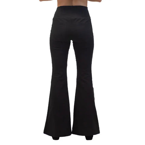 A person is pictured from behind wearing Spiritex | Sustainable Apparel’s high-waisted Lycra Bell Bottoms in black. The photo, cropped above the waist, only shows the pants made from organic cotton.