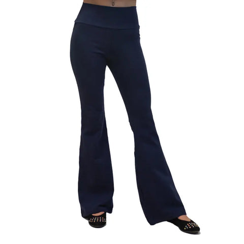 A person wears navy blue Spiritex Lycra Bell Bottoms, made from organic cotton, and black studded flats. Their upper body isnt visible, and the background is white.