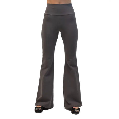 A person wearing Spiritex | Sustainable Apparels high-waisted, dark grey Lycra Bell Bottoms, shown from the waist down against a white background, paired with black studded sandals.